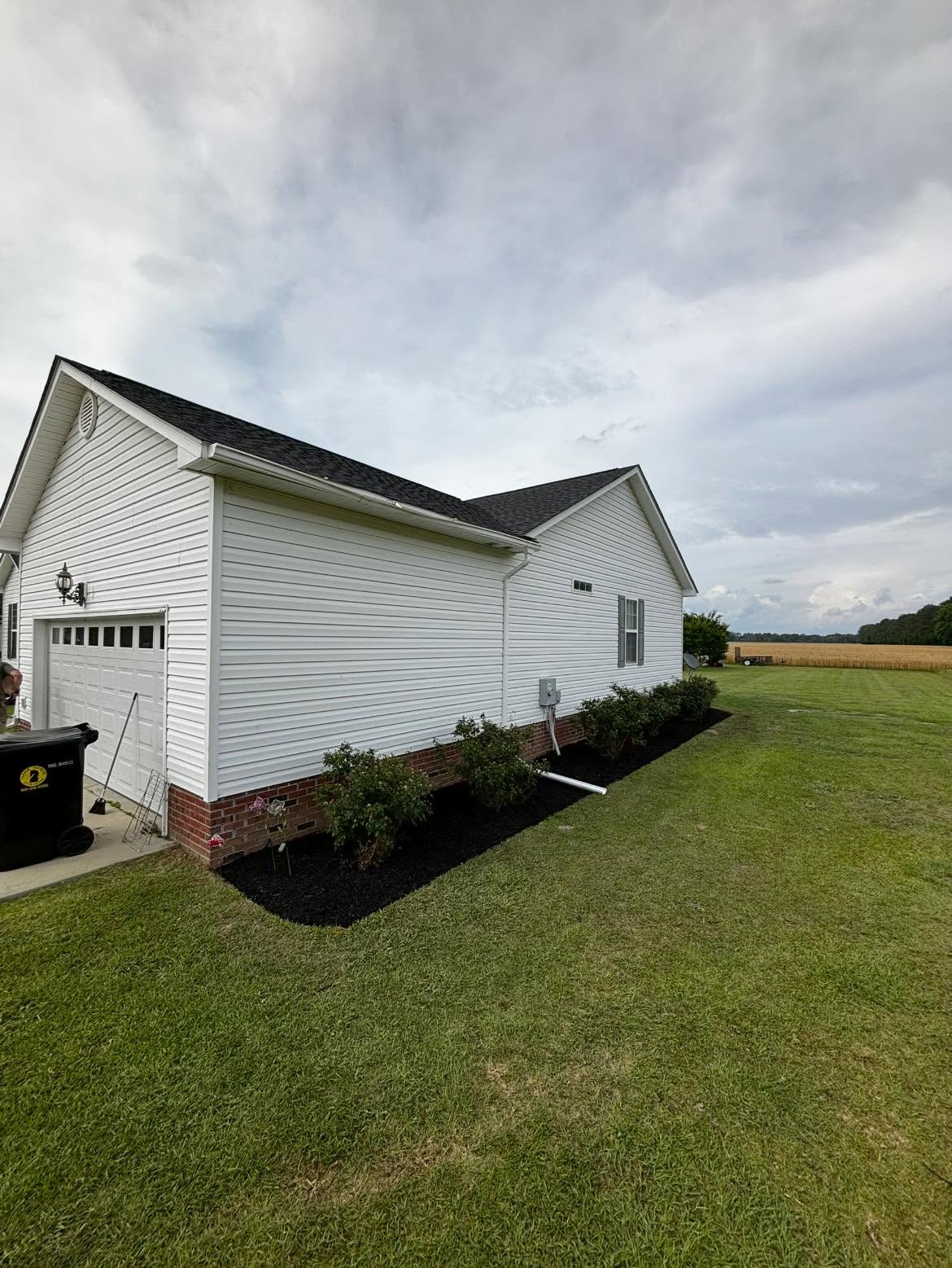 Clean mulched landscape bed along the side of a house, after